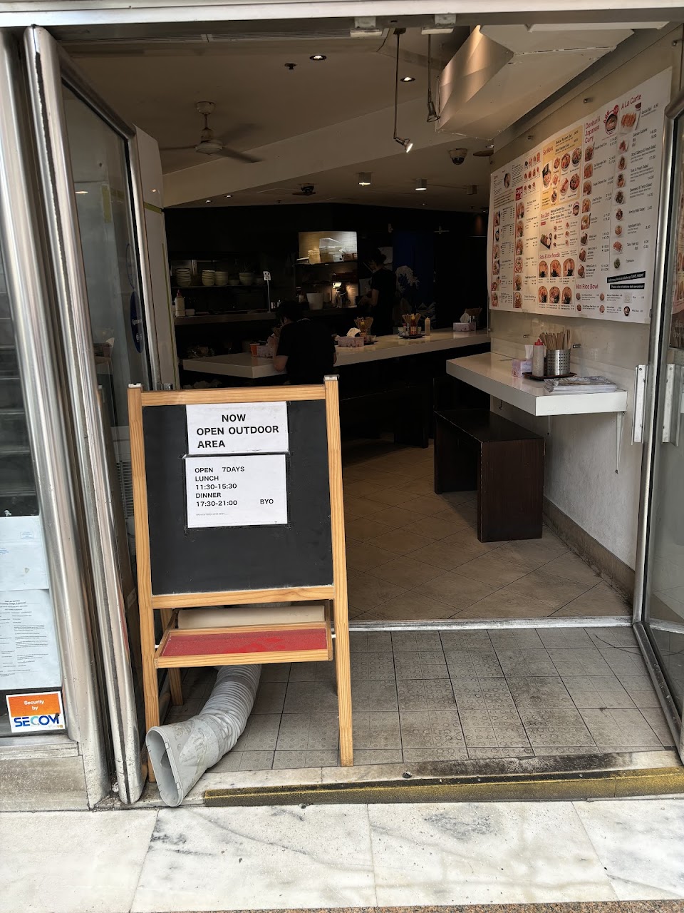 Entrance to Menya Chinatown in Haymarket with menu boards inside